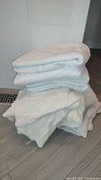 Stack of folded white towels on the floor