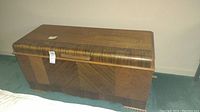 Front view of vintage Lane cedar chest showing wood grain pattern, handle, and top surface with light wear.