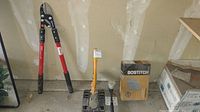 Overall lot overview showing bolt cutters, floor stapler, staples box, rubber mallet