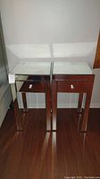 Pair of matching mirrored nightstands side by side showing full height and reflective surfaces.
