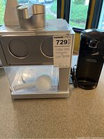 Snow cone maker and electric can opener side by side on kitchen counter with visible cords