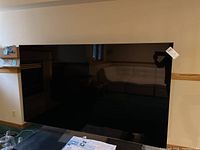 Full front view of the 75" Sony BRAVIA black flat screen TV on a table with price tag