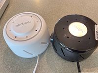 Top-down view showing the white Morphee and black Shoji white noise machines side by side.