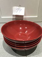 Stack of 4 large red pasta bowls showing size and color