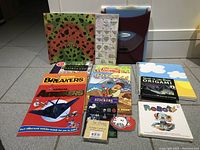 Photo of the collection showing origami books, sample papers, sticker pack, and two aircraft builder booklets.