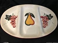 Top view of the oval divided platter showing pear in center and grapes on sides.