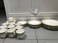 All pieces arranged on floor: cups, saucers, salad and dinner plates visible
