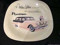 Photo showing front view of the metal plate with image and text describing the 1955 Pontiac Station Wagon in Avalon Yellow and Raven Black.