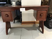 Front view of the wooden secretary desk showing two drawers with wooden knobs and curved legs.
