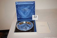 Sterling silver Christmas plate in original blue satin-lined box with certificate and labeling visible.