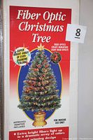 Front of original box showing image of fiber optic Christmas tree with multicolor lights and star topper in gold base, highlighting features like super bright array and ever changing colors