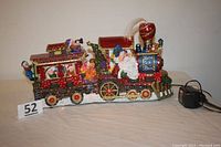 Full view of the fiber optic Santa's train including Santa figure in locomotive and elves in train car with power cord visible.