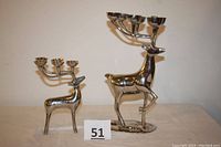 Both silver-tone deer candle holders displayed together showing size difference and base detail.