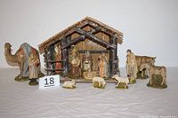 Full view of the entire nativity scene set with manger and figurines arranged on table.