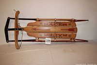 Full top view of the sled showing wood slats with Classic Racer graphics and steel frame with red runners