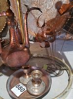 Photo of the hammered copper decanter or pitcher, the copper tray, two candle holders, and the copper sculpture with curved floral elements on rods
