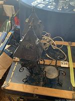 Shows two iron lamps with pyramid metal tops, chunky colored glass embedded in sides, sitting on decorative bases with curled iron feet, untested with cords visible