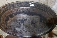 Full view of oval brass tray leaning against wall