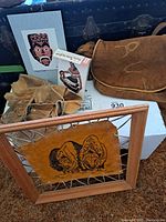 Overview of entire lot showing framed leather artwork, moccasins, leather bag, art prints, and additional leather pieces.