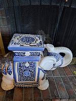 Front angled view of blue and white ceramic elephant plant stand showing detailed patterns on the body and the top surface.