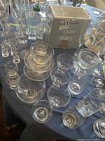 Overview of assorted Scandinavian glassware on a table including clear glass bowls, glasses, and decanter with original Tapio box visible