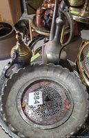 Top-down photo showing large engraved silver-toned brass platter with floral and geometric patterns.