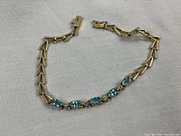 Full view of the bracelet laid flat on white fabric