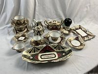 Overview of entire set on white backdrop showing all cups, saucers, plates, dishes and accessories