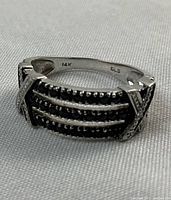 Angled side view showing interior hallmarks “14K” and “GLS” along with the black onyx rows