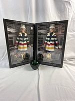 Two boxed Barbie Silver Label dolls side by side with green apple size reference