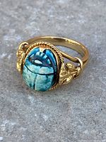 Front-angle view showing carved scarab and gold setting