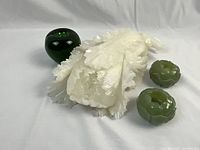 Group view: white jade flower sculpture with two green candle holders and reference apple