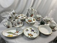 Wide view of full porcelain service collection on white drape