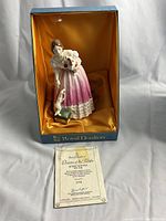 Porcelain figurine in original Royal Doulton box with certificate placed in front, satin lining inside box.