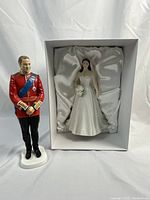 Catherine figurine in satin-lined box and William figurine standing beside box