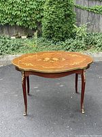 Front perspective showing scalloped oval top and cabriole legs with ormolu mounts