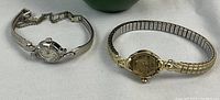 Two Bulova ladies watches displayed side by side, top view showing dials and bands.
