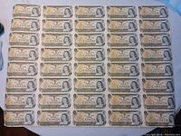 Full obverse view of the uncut sheet showing all 40 one-dollar bills with Queen Elizabeth II portrait