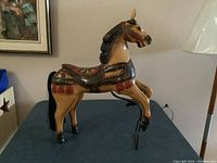 Full view of the wooden antique horse stand showing shape and painted details.