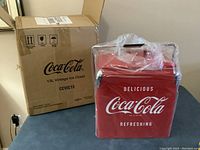 Photo of the Coca-Cola branded cardboard box with labeling '13L Vintage Ice Chest CCVIC13'.