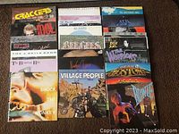 24 rock vinyl LP covers arranged in a 4x6 grid featuring bands such as Asia, Soft Cell, Peter Gabriel, Village People, Boston, Bon Jovi, Billy Idol, The J. Geils Band, Klaatu, The Police, Billy Joel and others.