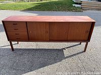Front elevation showing full length credenza with four sliding doors and four drawers