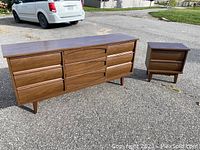 Full view of seven-drawer dresser and two-drawer side table outdoors