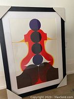 Framed Mid-Century Modern style abstract print with geometric shapes in vibrant colors including purple, red, black, orange, and brown, set in a black frame with white mat.