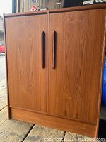 Front view of teak veneer cabinet showing two doors and recessed handles