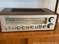 Front angle view showing faceplate controls and wooden cabinet