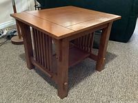 Three quarter angled view of the solid oak side/end table showing the top surface, slatted sides, and leg joinery.