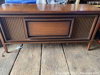 Full view of vintage walnut wood console with front panel and legs, showing overall condition and style.