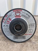 Close-up photo of a single cutting disc showing label with dimensions and brand Kompatitor