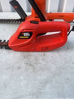 Close up of the smaller Black & Decker cordless hedge trimmer labeled 6.0V
